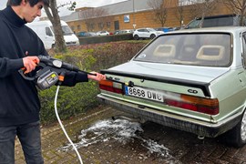 Man cleans car with cordless pressure washer