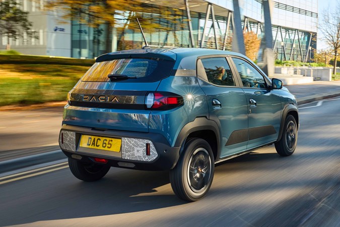 Dacia Spring review - rear, blue, driving in the UK