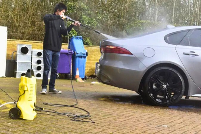 Aaron Hussain cleaning a Jaguar XF with a Karcher K2 pressure washer