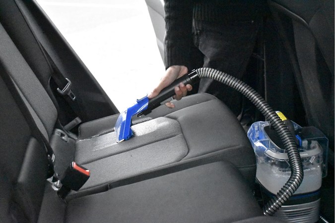 Vax SpotWash Home Duo in use, injecting shampoo into a car seat 
