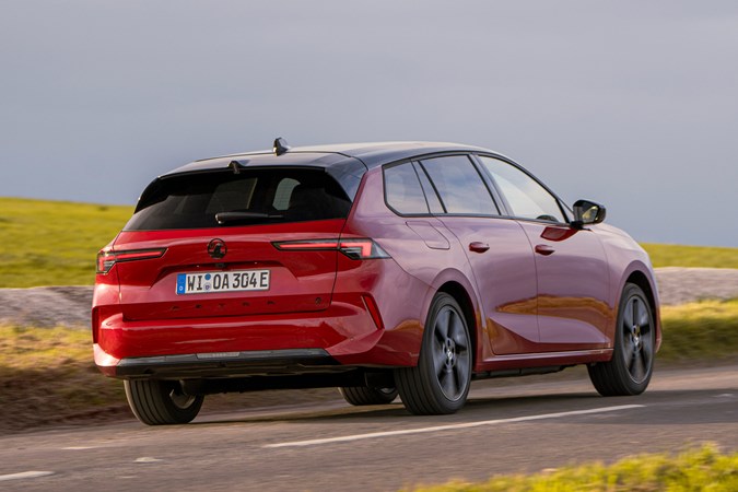 Vauxhall Astra Sports Tourer Electric (2023) review: rear three quarter cornering, British country lane, red paint