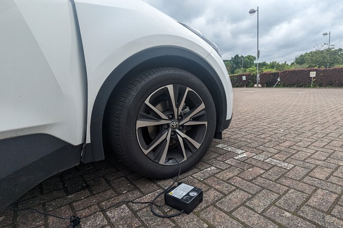 Toyota C-HR long-term review: front driver's wheel detail shot, connected to a tyre inflator, white paint