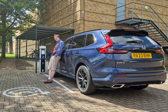 CJ Hubbard, Head of the Digital Automotive Hub at Bauer Media, standing next to Honda CR-V e:PHEV, which is plugged into electric car charger