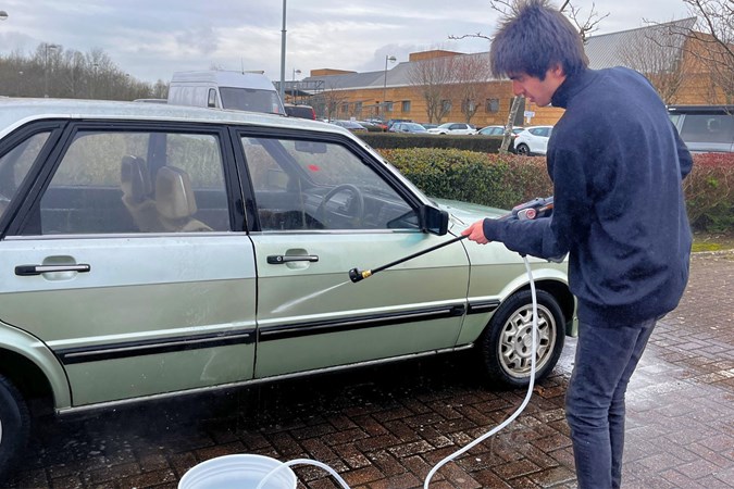 Using a jet of water to clean the door of a car