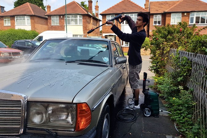 Aaron Hussain cleaning a car with a pressure washer