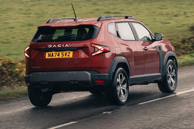 Dacia Duster review - rear, red, driving round corner