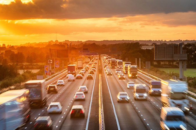 Bank holiday traffic: overhead view of flowing traffic on the motorway, sunset