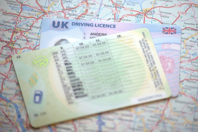 UK driving licence, resting atop a map