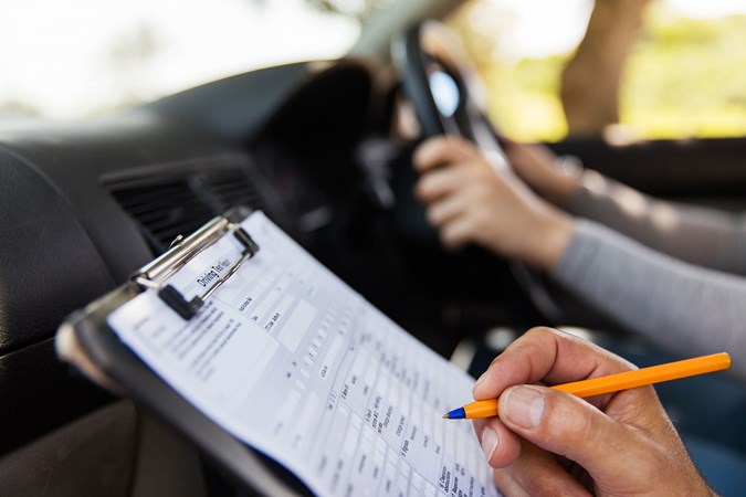 Driving test, examiner with clipboard in passenger seat