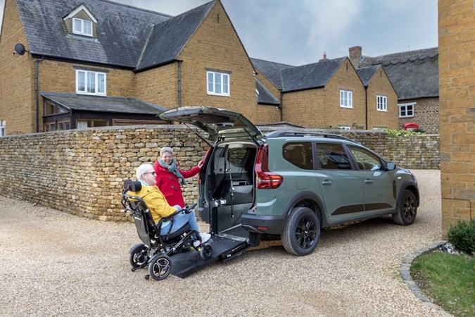 Image of a wheelchair accessible Dacia Jogger, with a wheelchair user about to go up the ramp