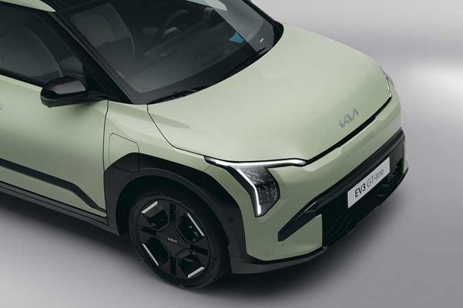Kia EV3 (2024) reveal: front three quarter detail shot of LED headlights, green paint, studio shoot