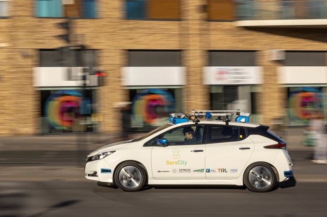 Autonomous vehicles: Nissan Leaf prototype, side view driving, white paint