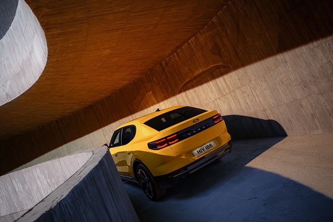 Ford Capri (2024) launch: rear three quarter static, studio shoot, down a multi-storey ramp, yellow paint