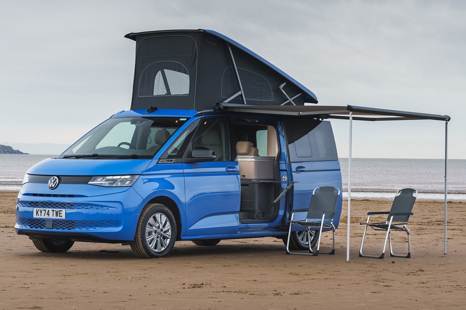Image of a blue Volkswagen California at the beach with its pop-top up | Parkers cars