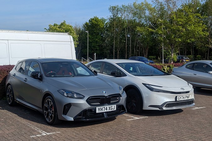 BMW M135 long-term test: front three quarter static, matte grey paint, with Toyota Prius