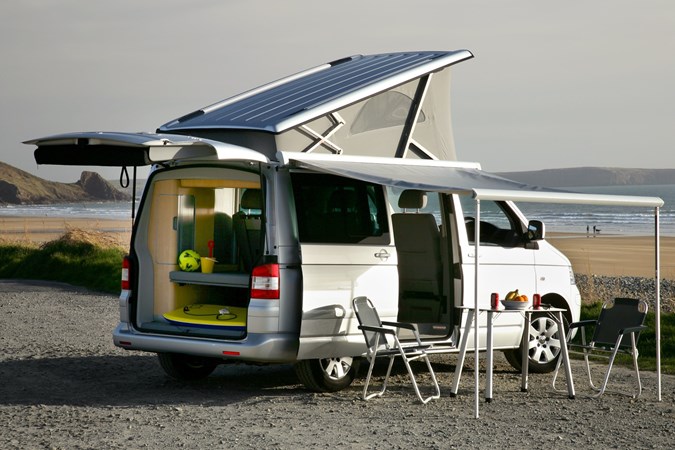 Image of Volkswagen T5 California, in silver, set for camping, viewed from the rear