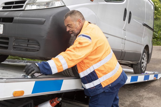 Image of a recovery driver loading a van onto his truck