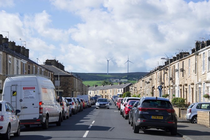 Image of cars parked on cars parked on both sides of a road in a small Lancashire town