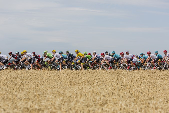 Image of a large cycling club peloton passing by the camera