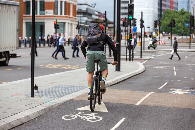 Image of a cyclists in a cycle lane approaching traffic lights