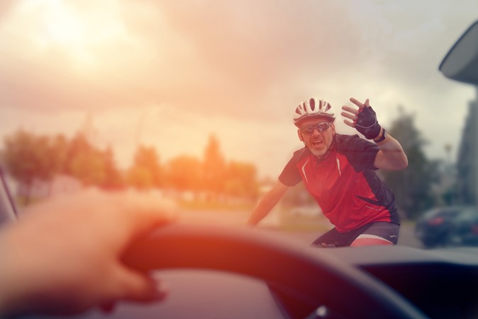 Image of a cyclist expressing displeasure with a driver