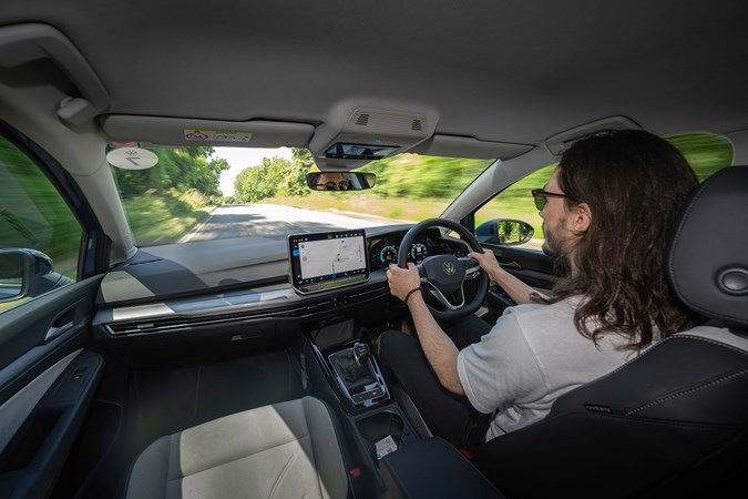 Volkswagen Golf (2024) review: Luke Wilkinson driving, black and grey fabric upholstery