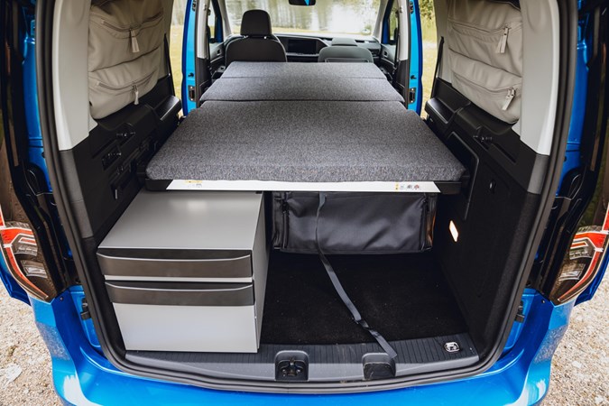 Image of the Volkswagen Caddy California interior with the bed folded out