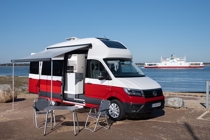 Image of the Volkswagen Grand California parked up on a quayside, with awning and outdoor furniture