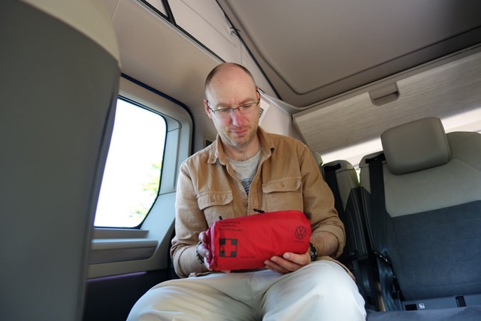 Man looking through a first aid kit in a campervan