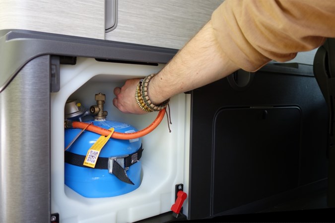 Close-up image of a campervan gas bottle being disconnected