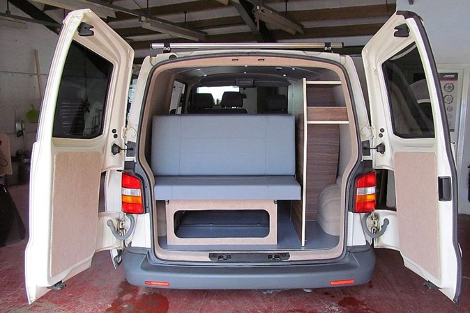 Image of the living space in a Volkswagen Transporter DIY campervan conversion, viewed through the open rear doors