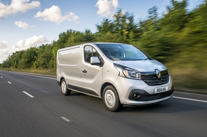 Image of a silver Renault Trafic driving on a country road, viewd from the front right corner