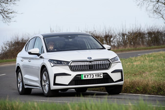 Skoda Enyaq Coupe (2024) review: front three quarter cornering, white paint, British country road, offset angle