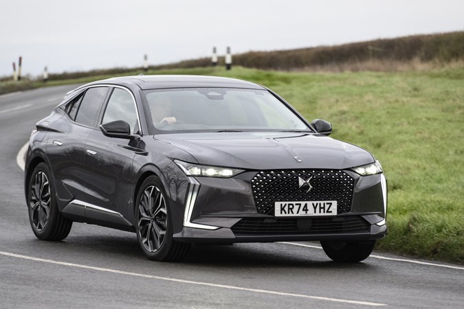 Image of a DS 4, in grey, driving round a right-hand corner, viewed from the car's front right corner