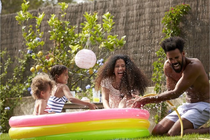 Family having fun in the garden by the inflatable pool