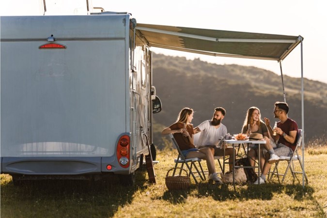 Friends enjoying a chat outside their camper van in a pretty country location