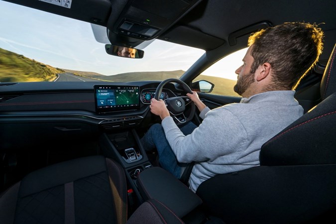 Image of a man driving a Skoda Octavia, seen from the back seat