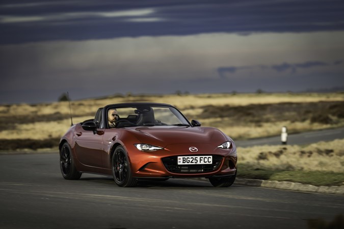 Image of a red Mazda MX-5, viewed from the front right corner while going round a corner