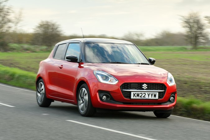 Suzuki Swift (2023) review: front three quarter driving, red paint, rural background