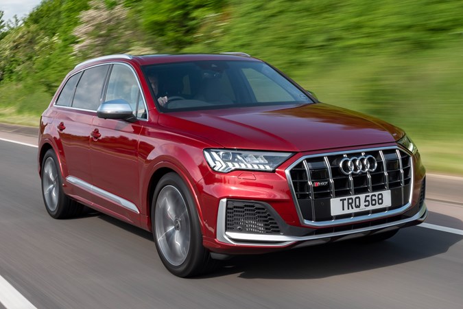 Audi SQ7 review (2022) - front three quarter rolling shot, red car, leafy road